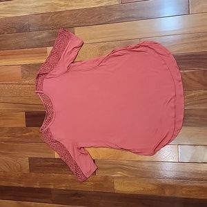 Women's short sleeve shirt with lace around the neck in back and on the sleeves.